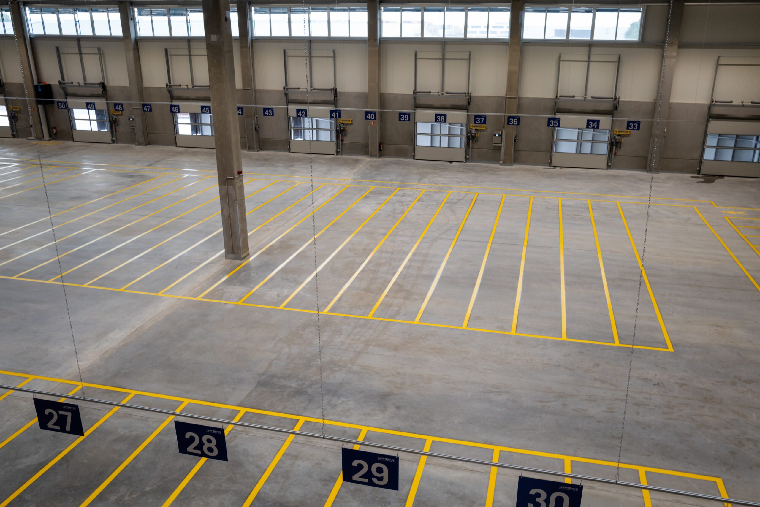 Bodenmarkierungen und von der Decke abgehängte Schilder von ONK in Nürnberger Logistikanlage von Rhenus Road Freight